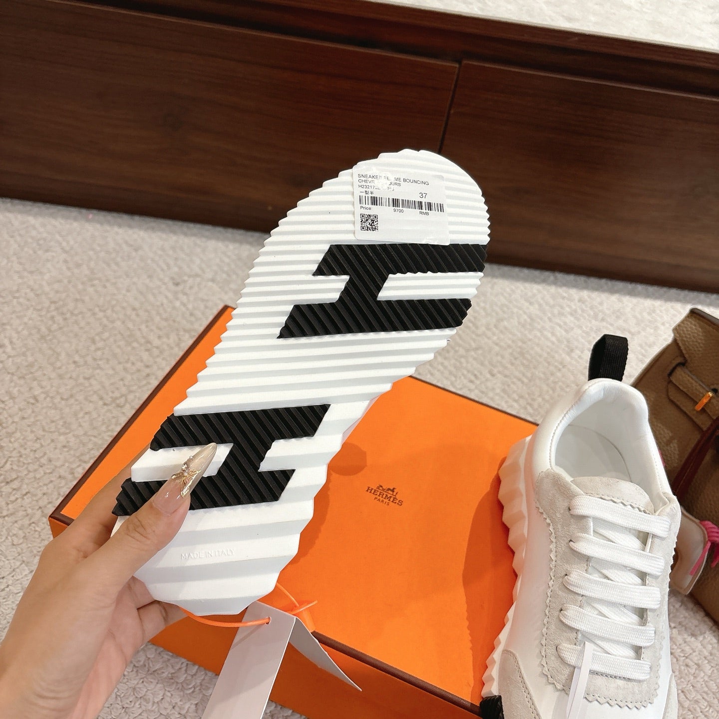 Hermes sneaker outsole view on orange box, striped rubber tread with size label