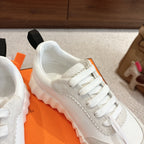 Hermes white unisex sneaker close-up, side profile with white laces and textured midsole