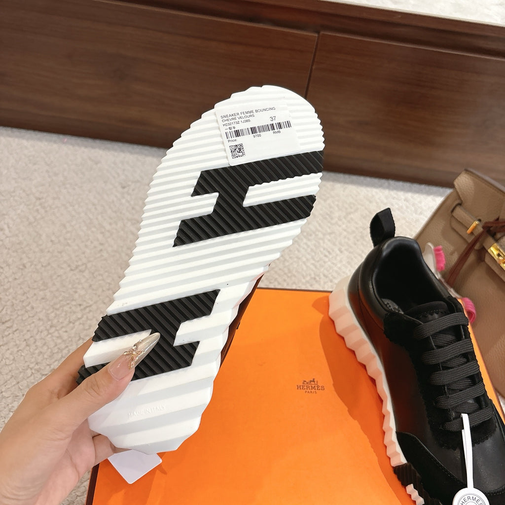 Hermes unisex sneaker outsole view: black tread, thick white sole, heel pull tab