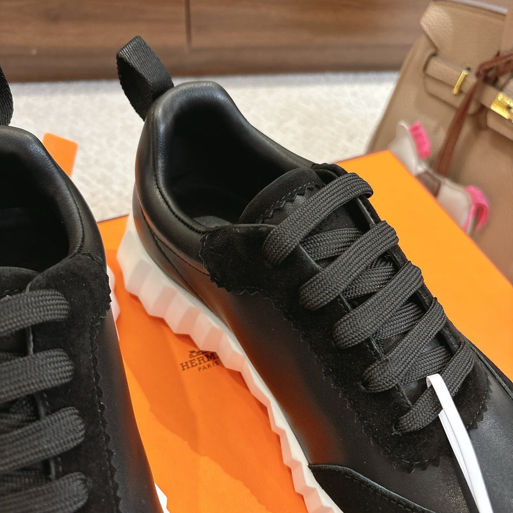 Hermes unisex sneakers close-up: black laces, smooth upper, thick white sole