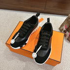 Hermes unisex sneakers, black lace-up style with white textured sole and side logo