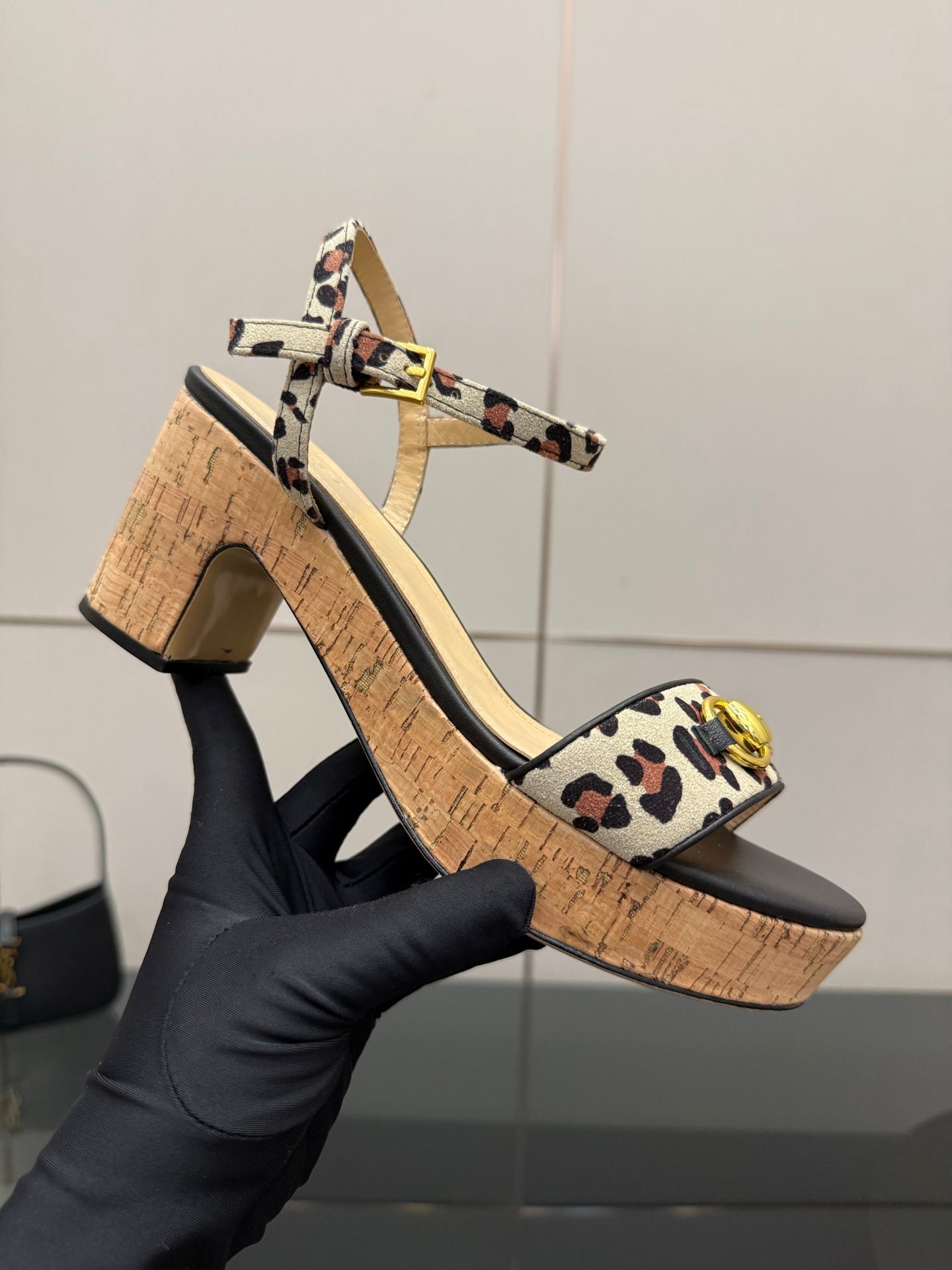 Leopard-print platform wedge sandal on hand with block heel