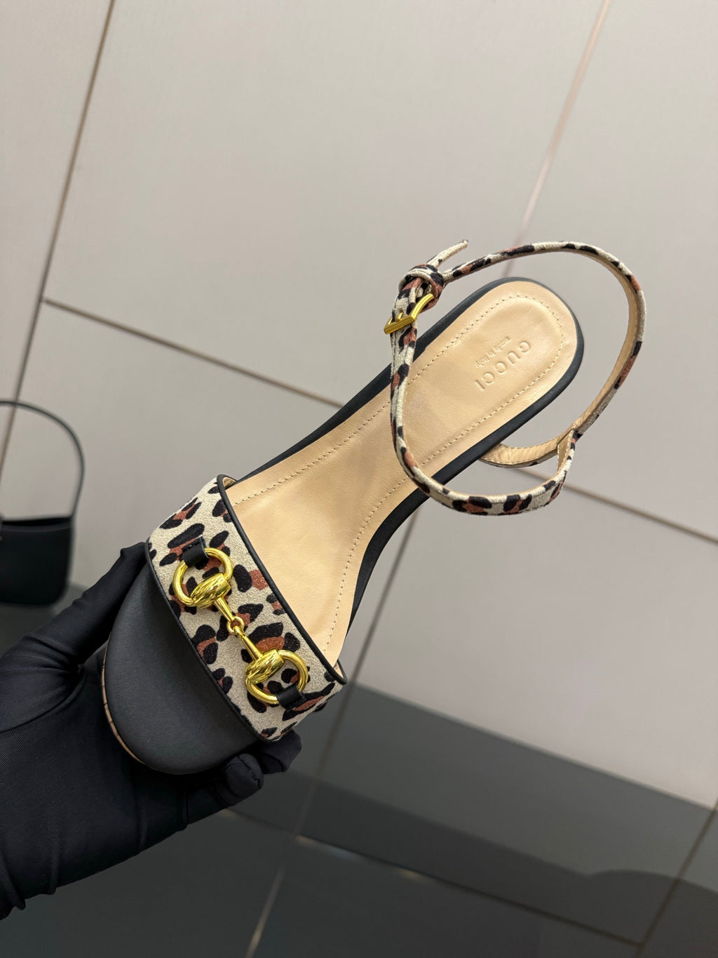 Leopard-print strap sandal upper with ankle buckle, shown close-up