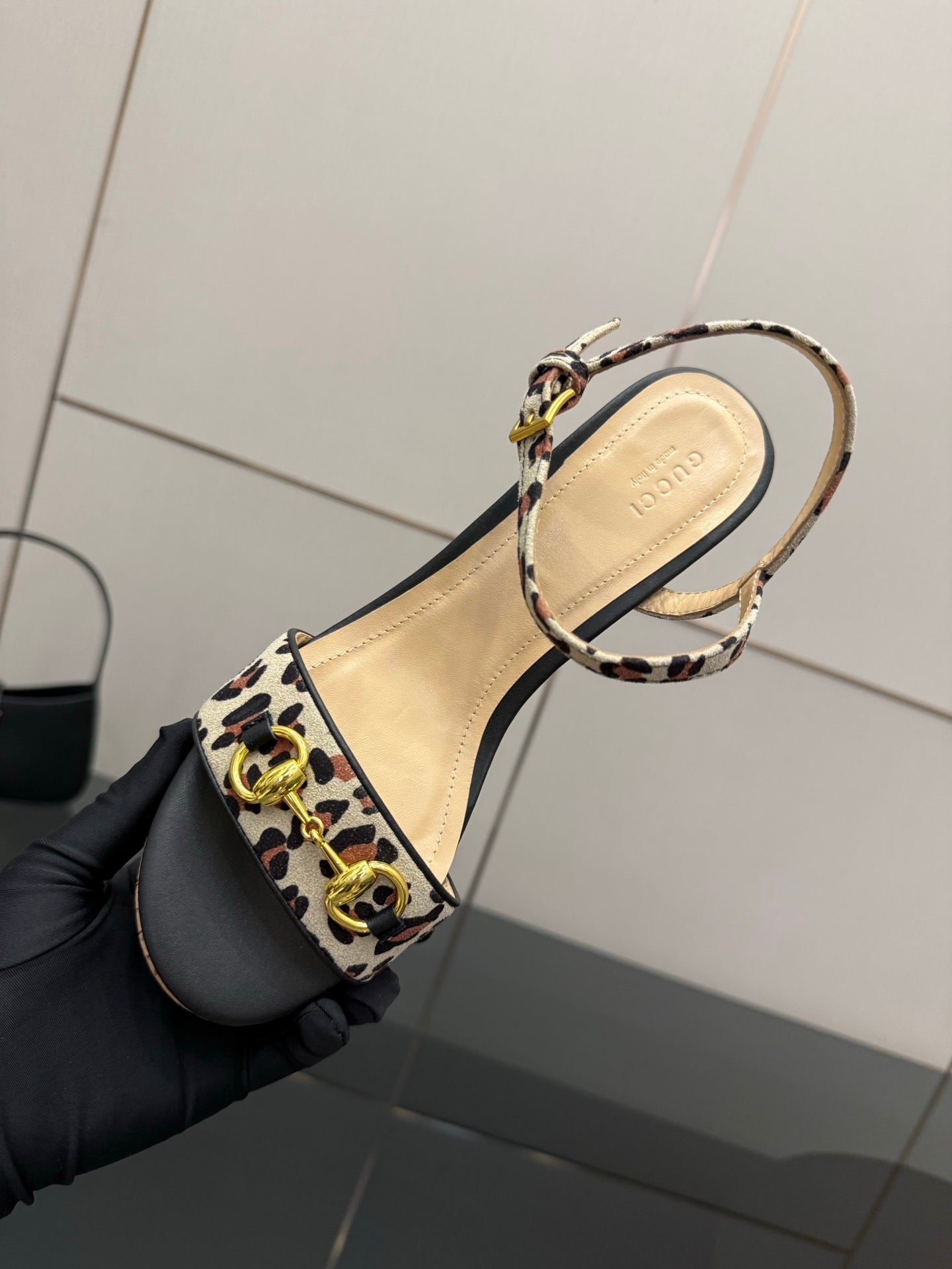 Leopard-print strap sandal upper with ankle buckle, shown close-up