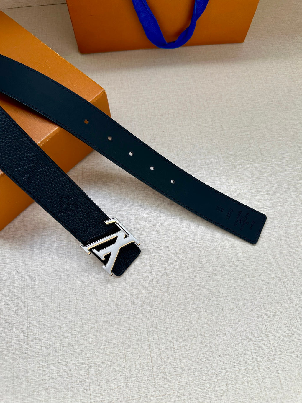 Louis Vuitton belt, dark leather strap with silver-tone LV buckle detail