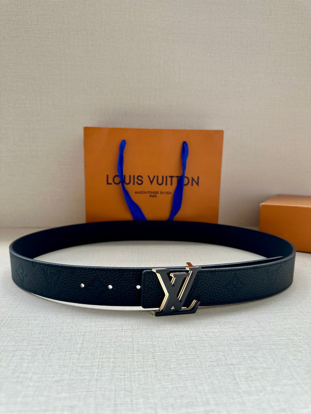 Louis Vuitton belt with dark textured leather strap and gold-tone LV buckle