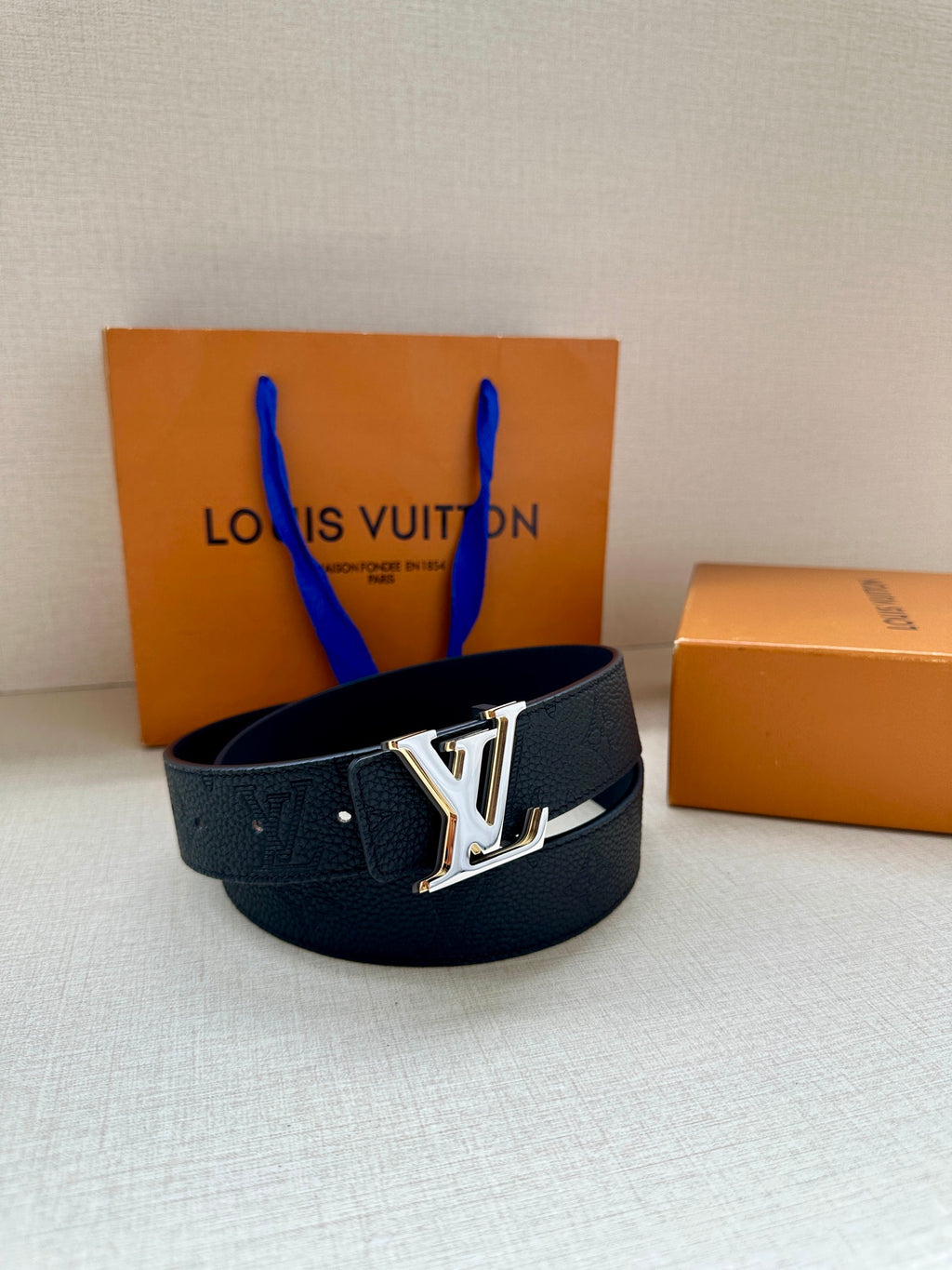 Louis Vuitton belt with dark textured strap and gold-tone LV buckle