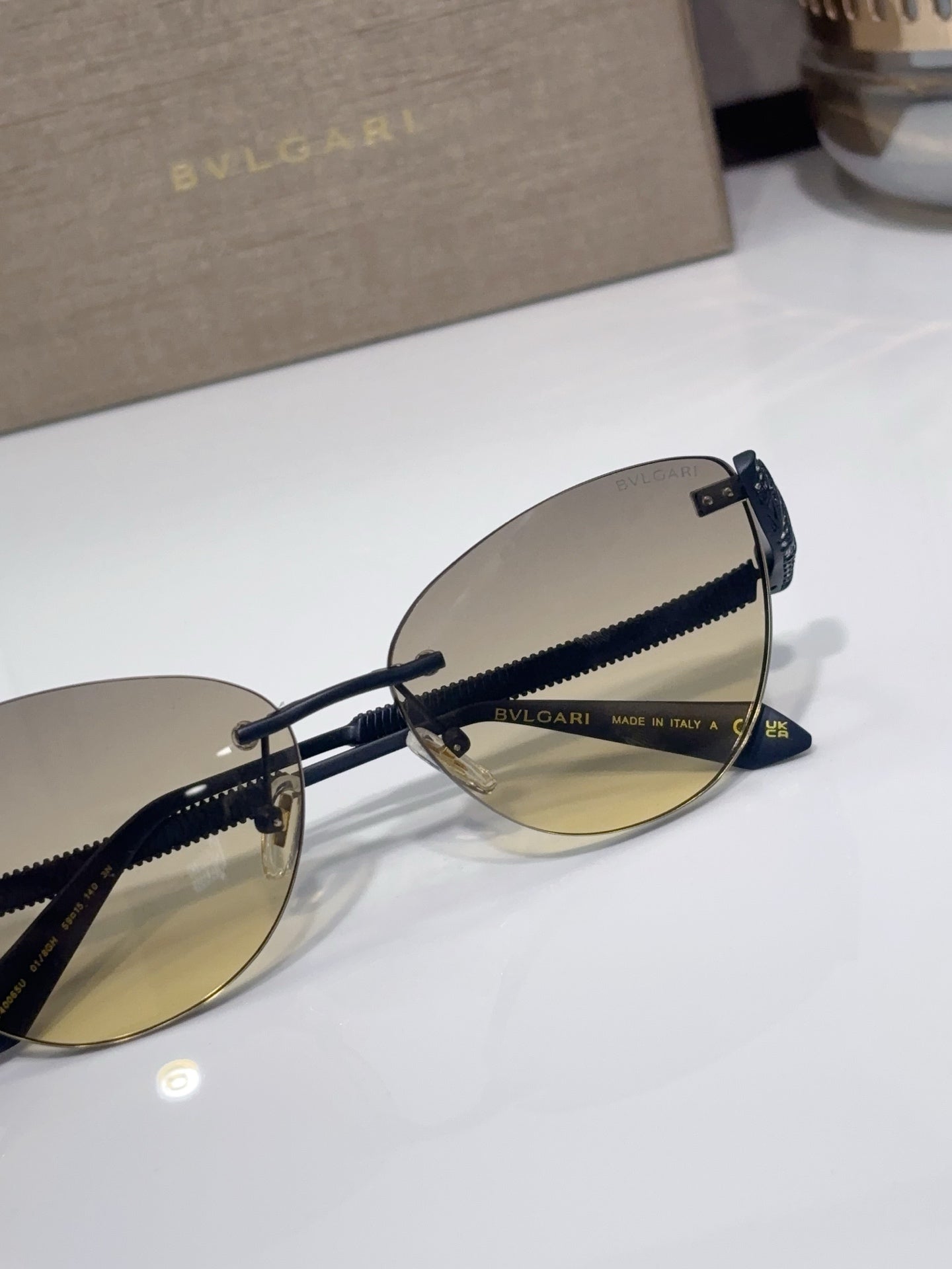 Aviator sunglasses with black frames and gold-tinted lenses, close-up of temples