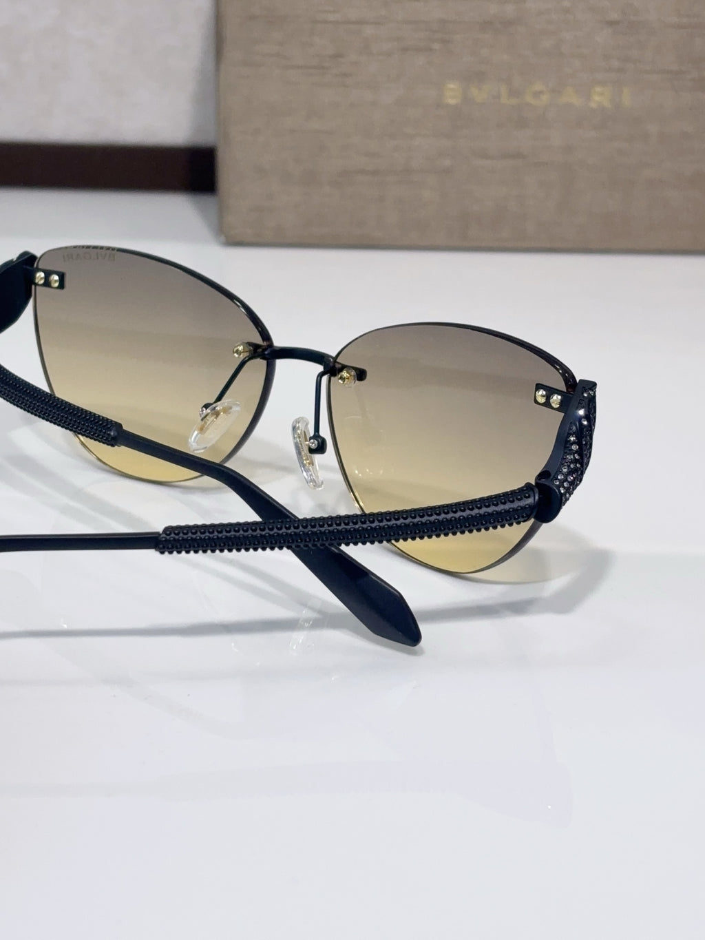 Navy-blue aviator sunglasses with gold-tinted lenses and beaded textured arms