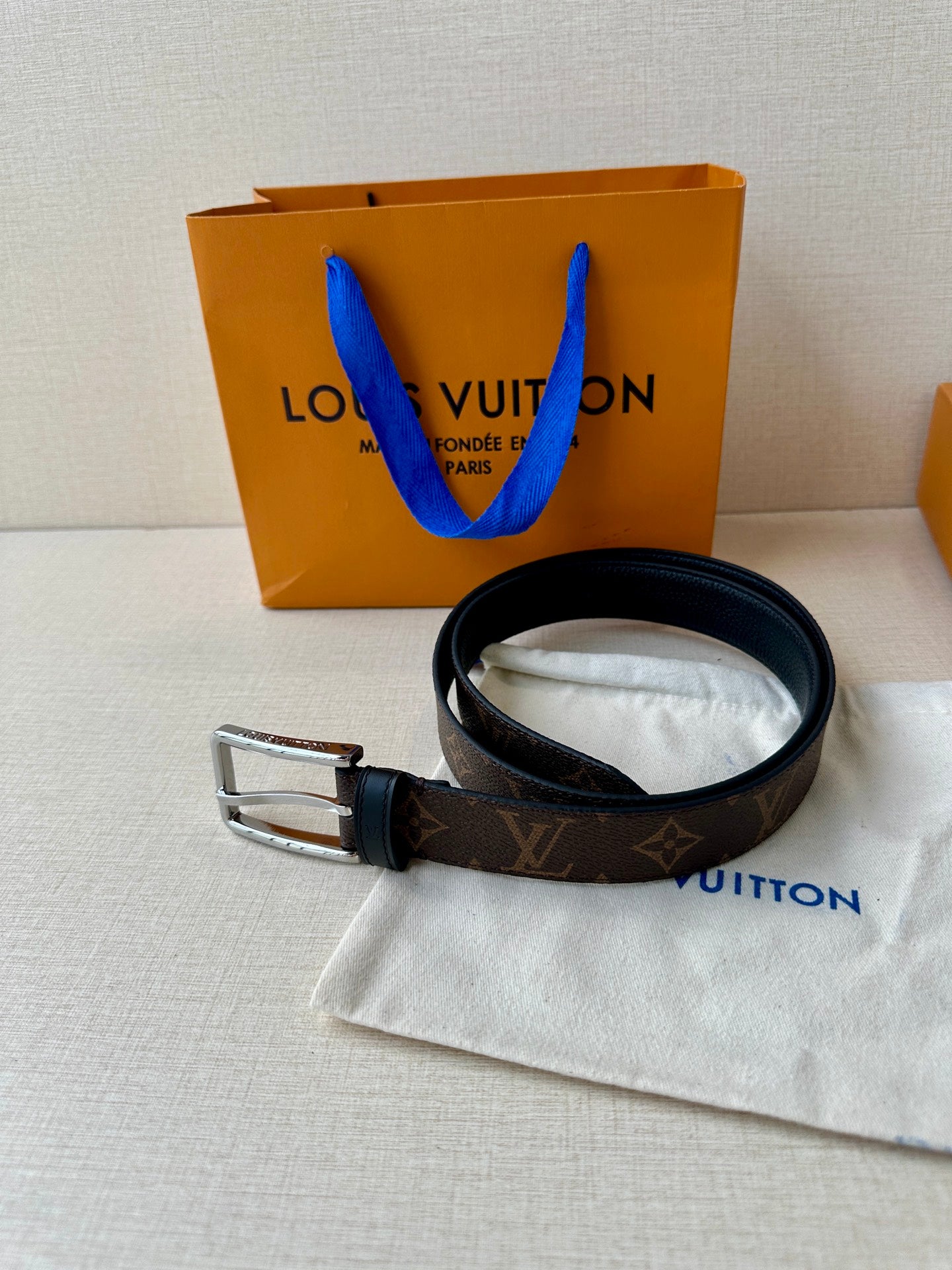 Louis Vuitton monogram belt with dark strap and silver buckle, with white dust pouch