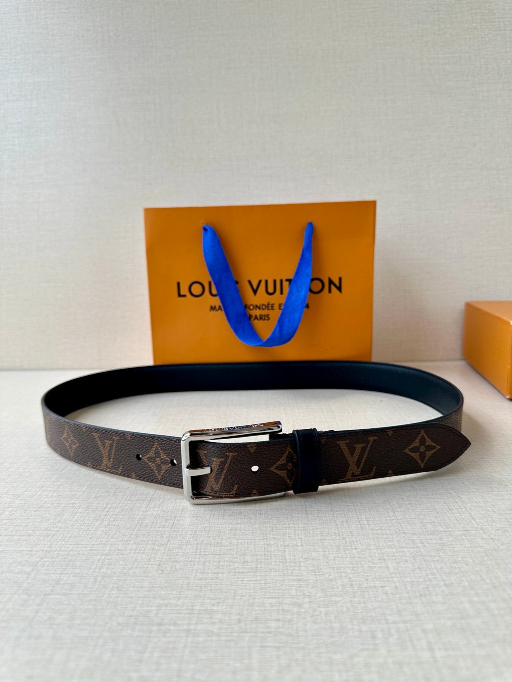 Louis Vuitton monogram belt with dark buckle and silver hardware, black leather strap