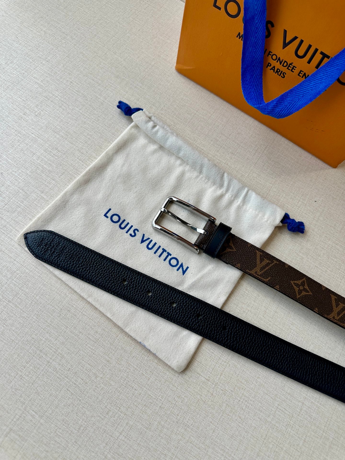 Louis Vuitton belt with dark leather strap and silver double-prong buckle, in dust bag