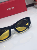 Cat-eye glasses detail with navy frame and yellow lens