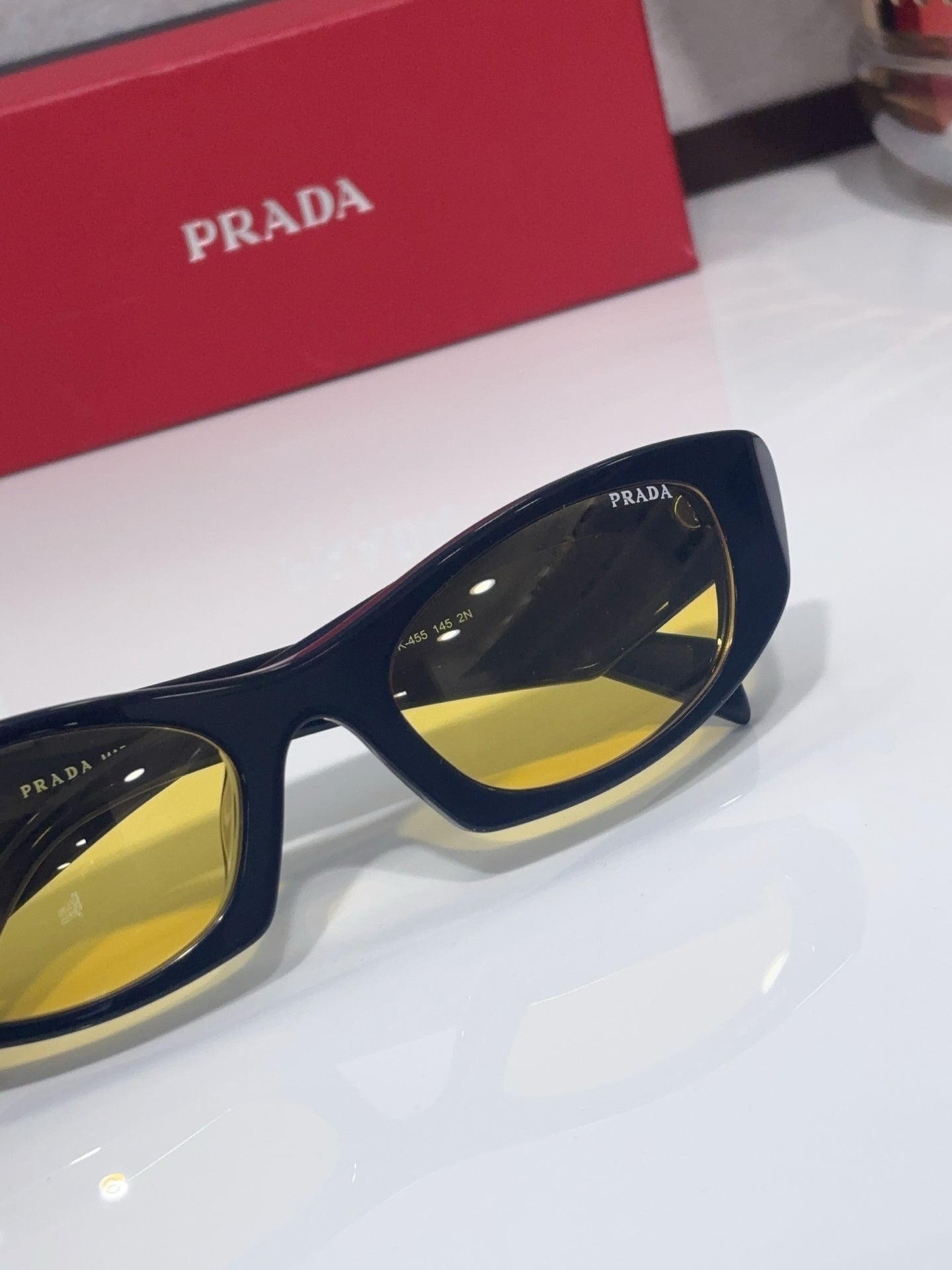 Cat-eye glasses detail with navy frame and yellow lens