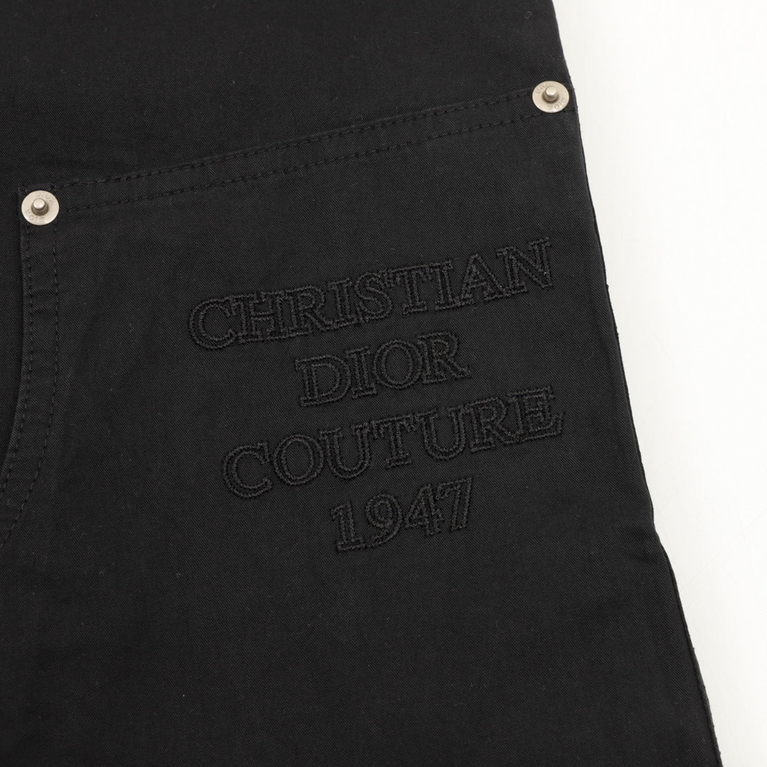 Embroidered text “DIOR COUTURE 1941” on dark pants