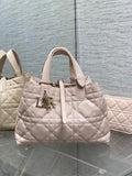 Light pink quilted handbag with top handles and front Dior logo charm