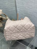 Light pink quilted handbag with front pocket and top handles