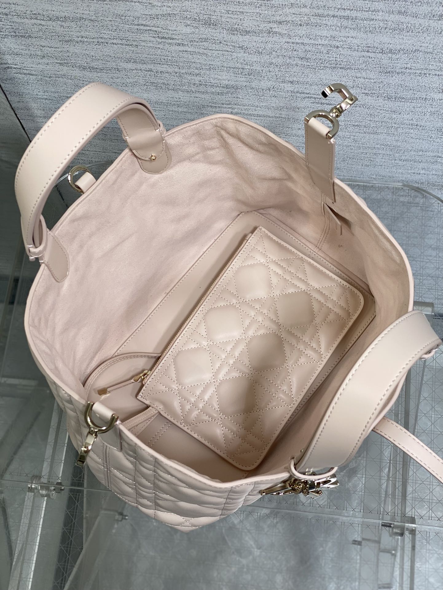 Light pink quilted handbag open with interior zip pocket and side handles