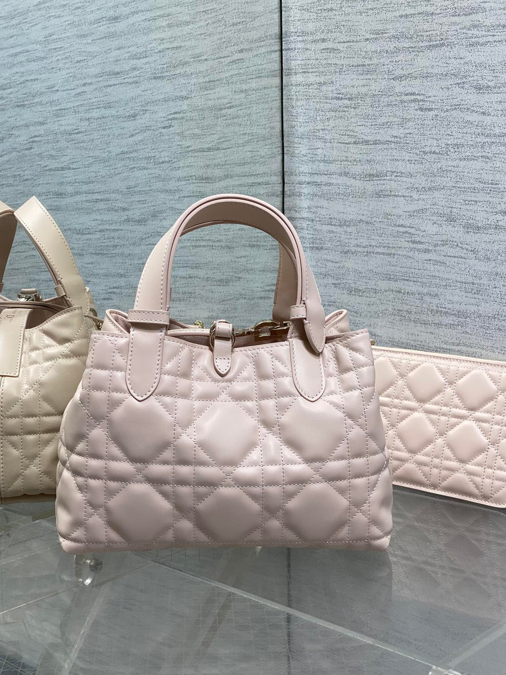 Dior quilted handbag in light pink with structured top handles and charm