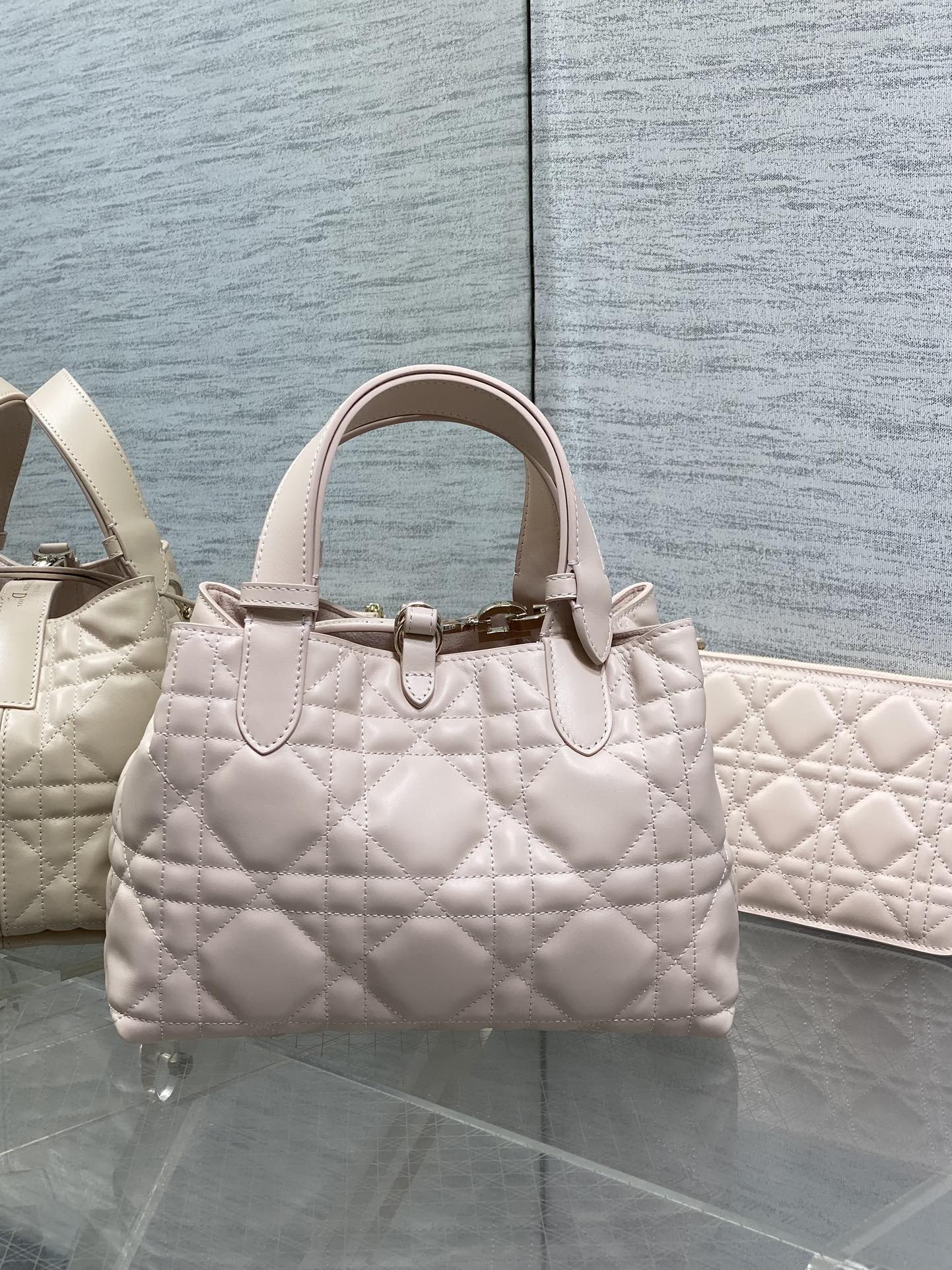 Dior quilted handbag in light pink with structured top handles and charm