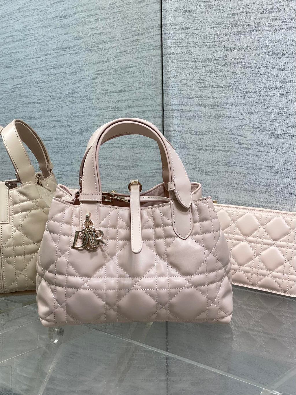 Dior quilted handbag in light pink with top handles and gold charm