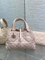 Dior quilted handbag in light pink with top handles and gold charm