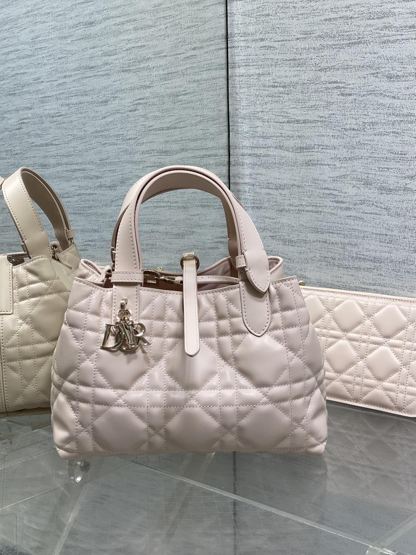 Dior quilted handbag in light pink with top handles and gold charm
