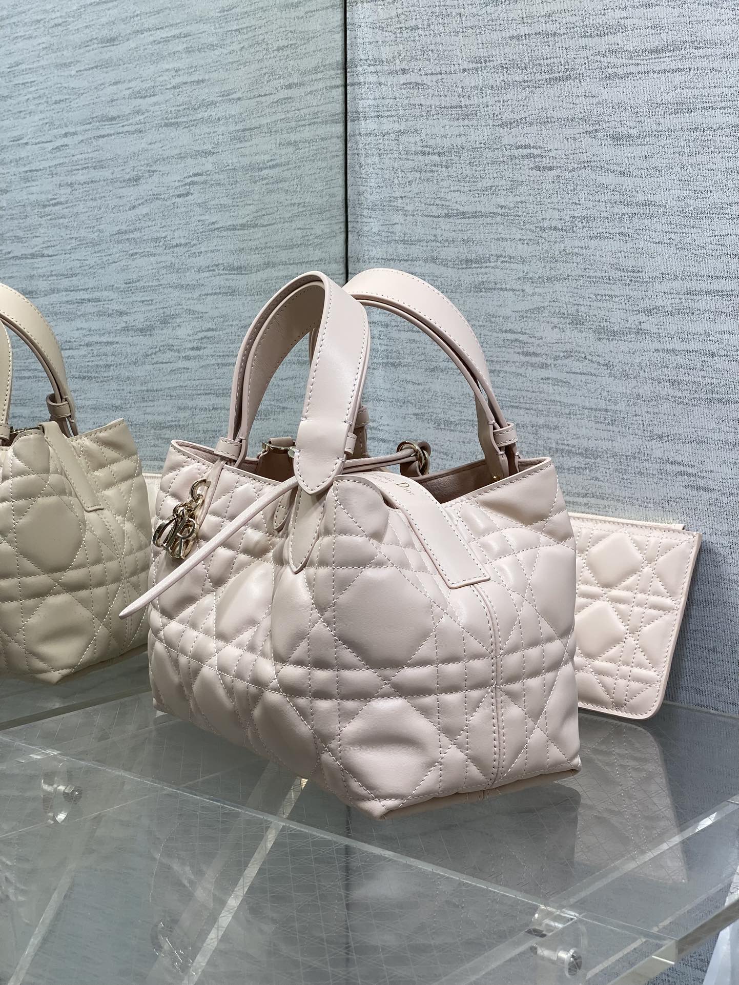 Dior quilted handbag in light pink with top handles and adjustable strap