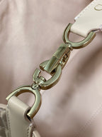 Dior handbag clasp and D-ring hardware in gold tone on light pink leather