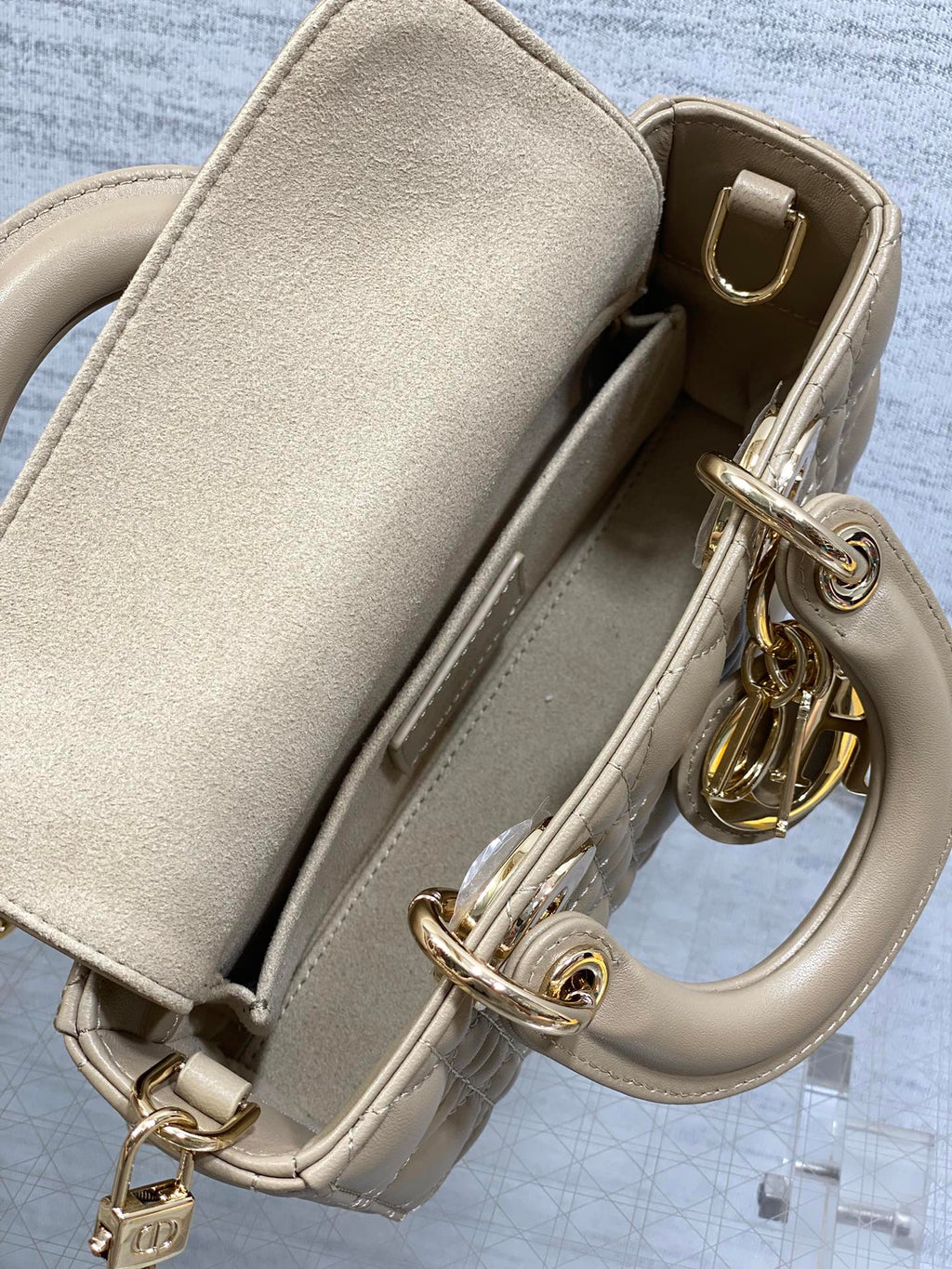 Beige handbag interior view with flap pocket divider and gold-tone clasp