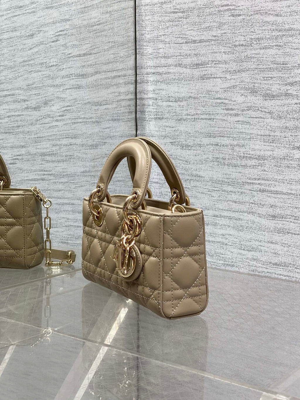 Beige quilted mini handbag with double top handles and gold-tone chain strap