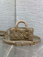 Beige quilted handbag with top handles, gold-tone hardware, and adjustable shoulder strap