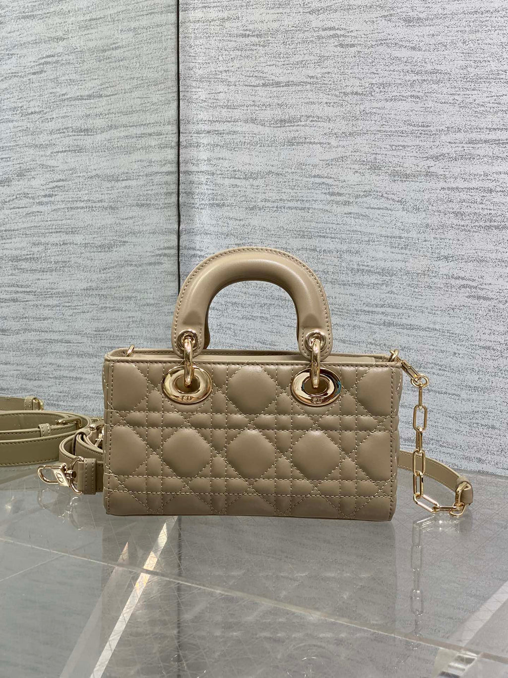 Beige quilted handbag with top handles and chain strap, front view