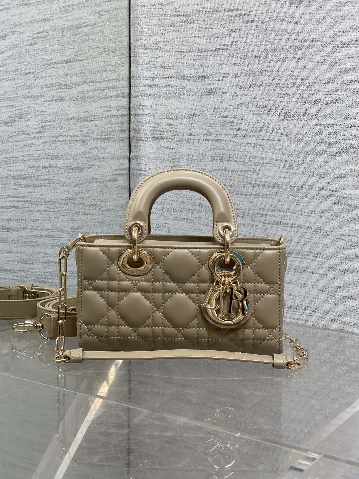 Beige quilted handbag with gold-tone rings and chain shoulder strap