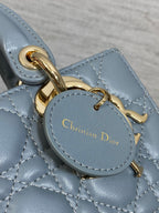 Dior handbag logo charm labeled "Christian Dior" on blue quilted leather
