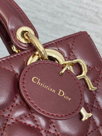 Dior logo medallion on burgundy leather strap with gold-tone hardware