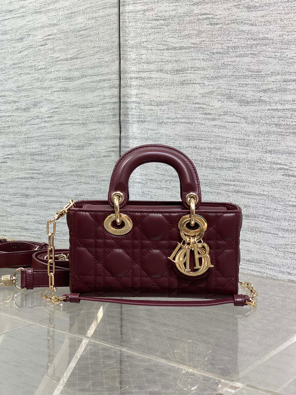 Dior quilted handbag front view with burgundy leather and gold-tone shoulder chain