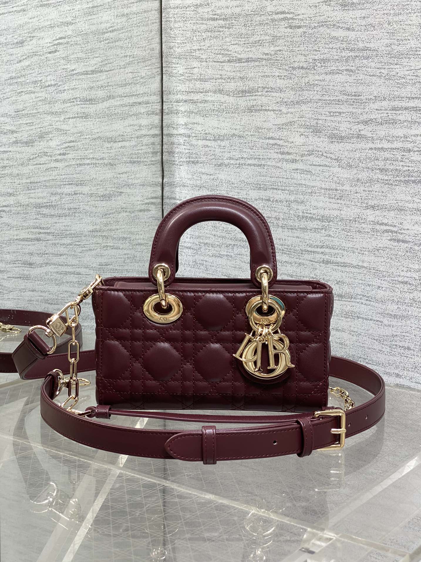 Dior quilted small handbag with top handles, burgundy leather, gold-tone logo charm