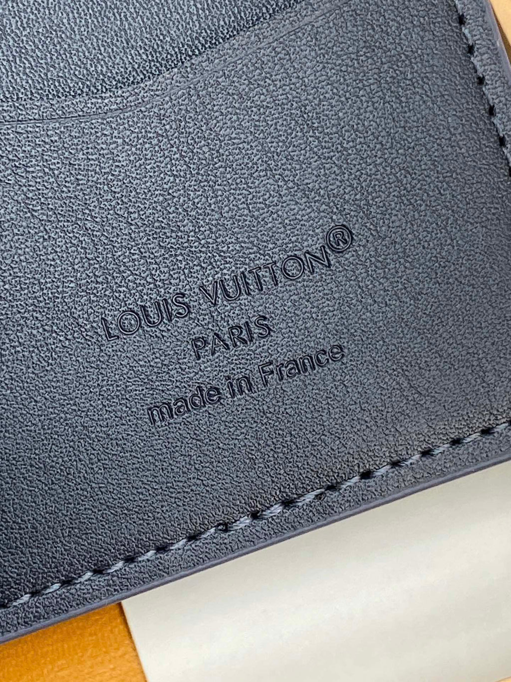 Close-up of Louis Vuitton card holder imprint, 'made in France' on dark blue leather