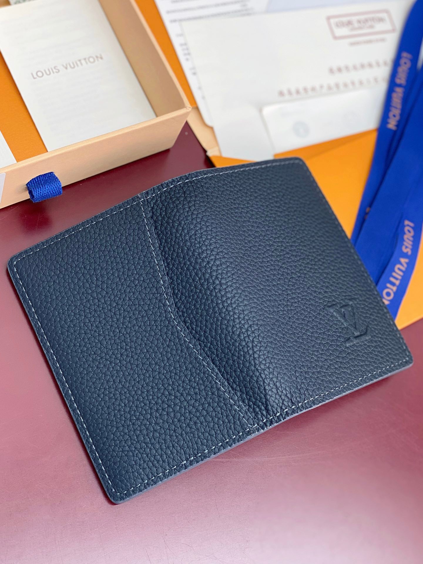 Small Louis Vuitton leather card holder, front view with subtle monogram embossing