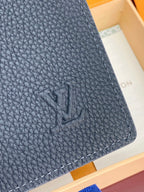 Close-up Louis Vuitton leather card holder corner, dark blue pebble texture