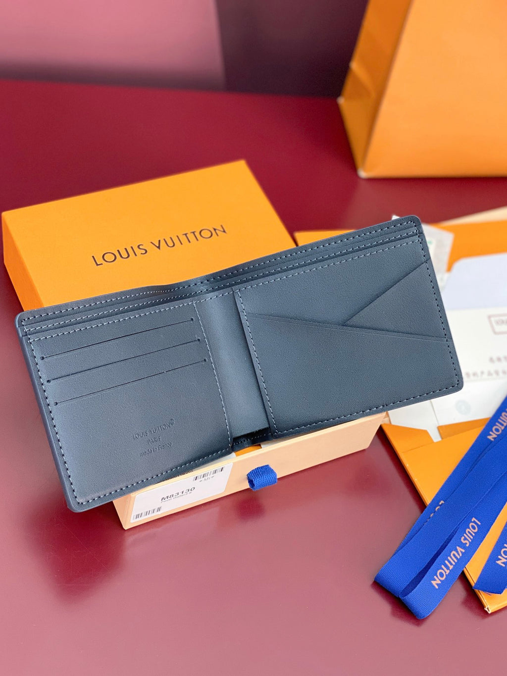 Louis Vuitton small bag, dark blue leather wallet open with card slots and pocket