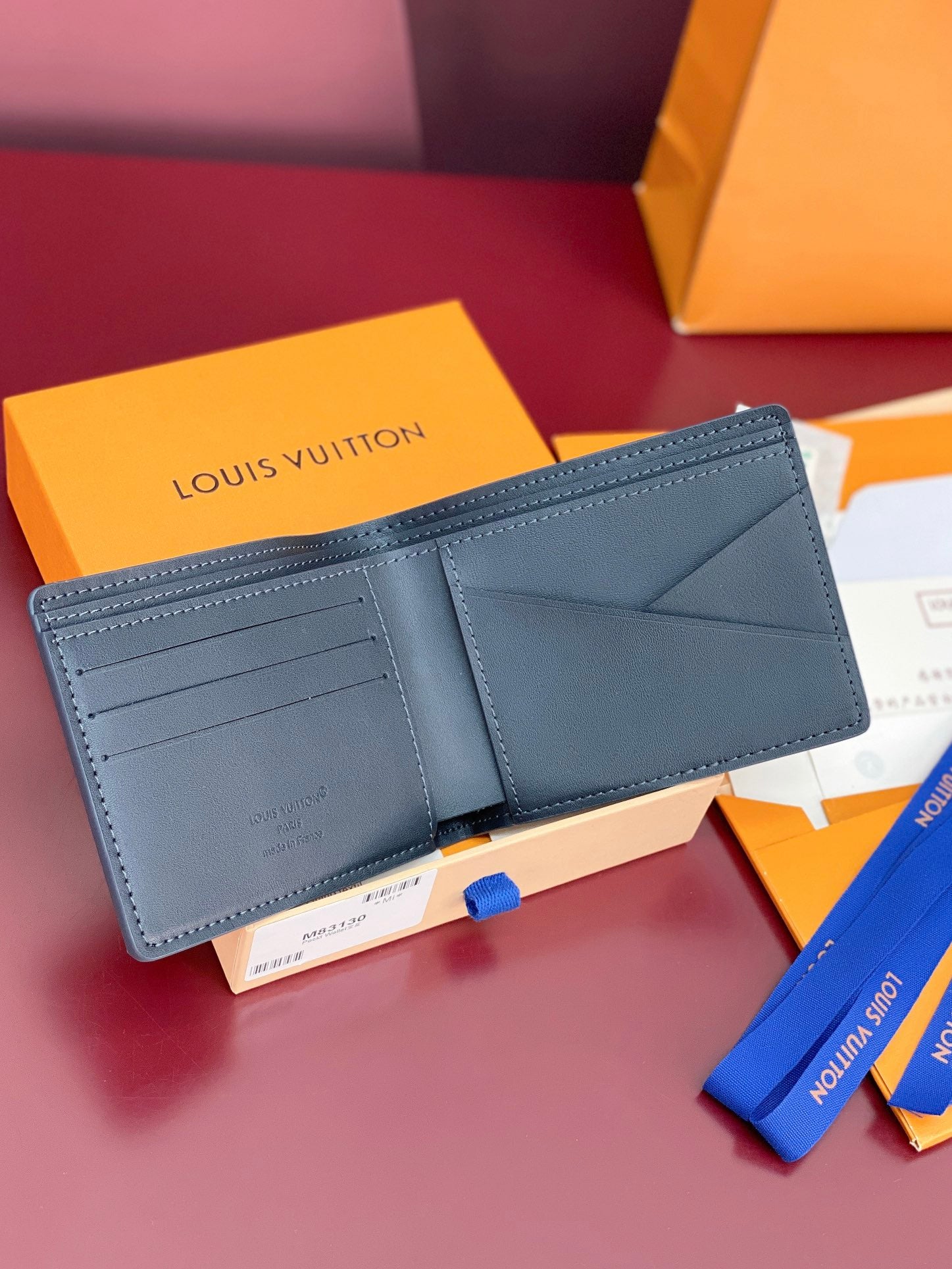 Louis Vuitton small bag, dark blue leather wallet open with card slots and pocket
