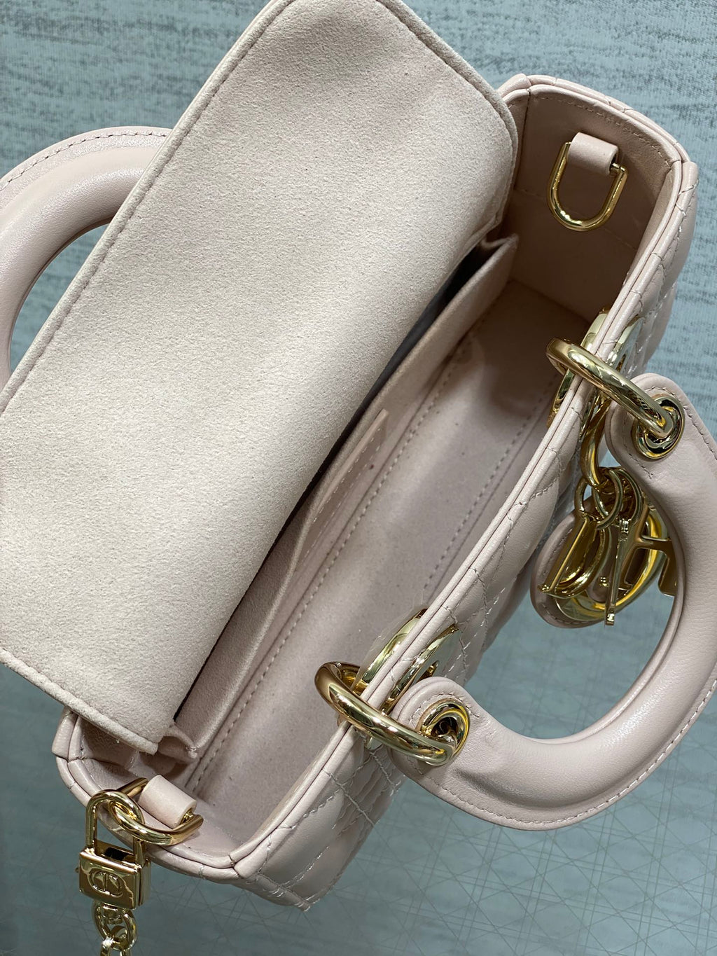 Light pink Dior bag interior with leather strap and gold clasp hardware