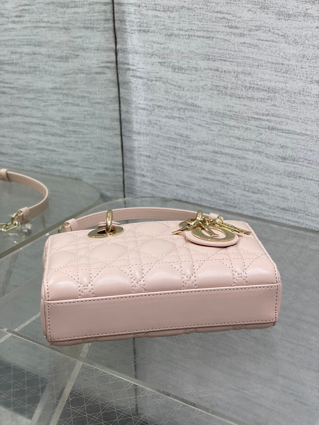 Pink quilted Dior bag with gold top handle and clasp, top view