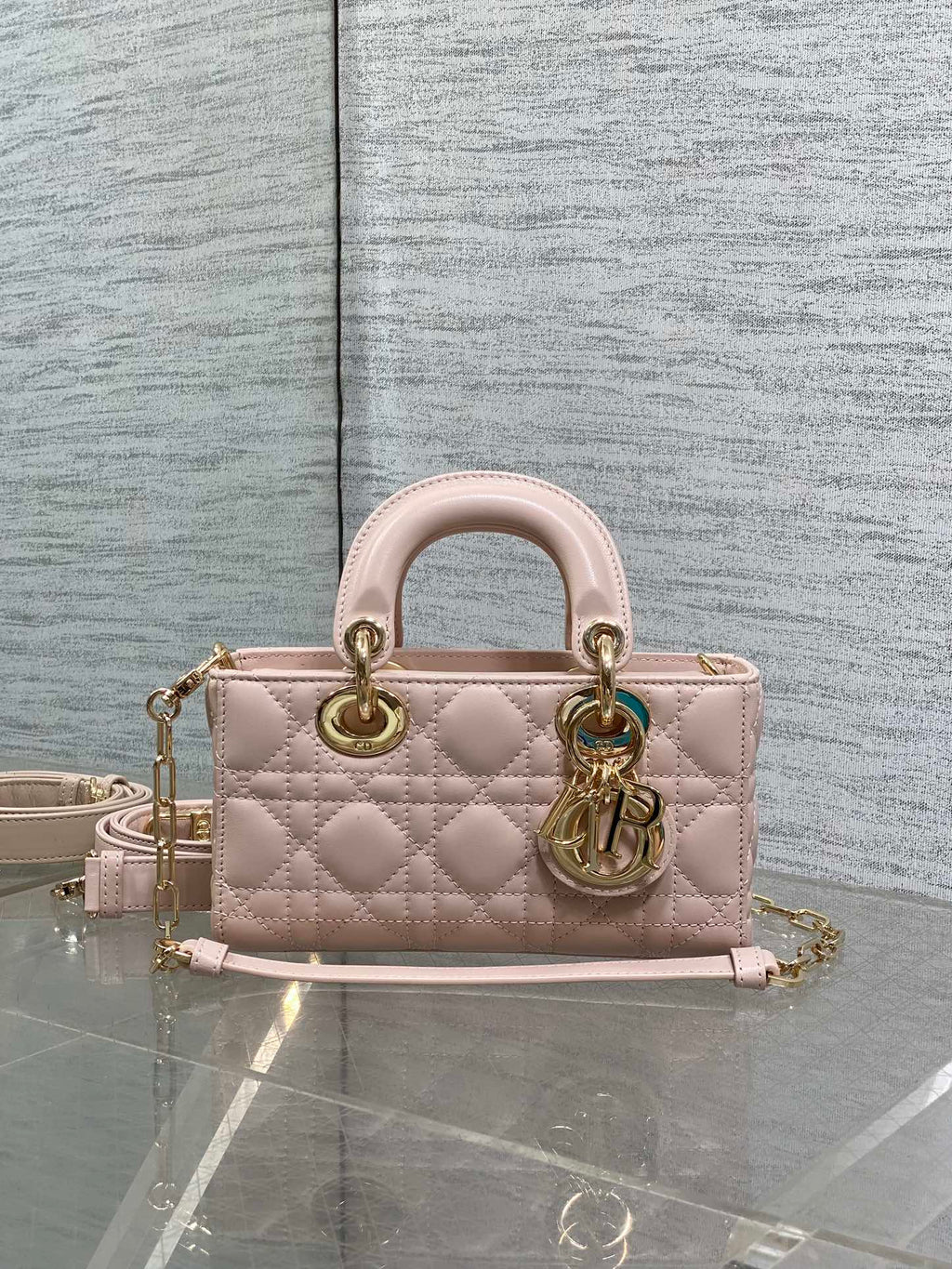 Pink quilted Dior bag with handles and adjustable shoulder strap, gold hardware