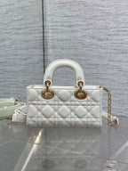 Quilted white handbag with two top handles, gold hardware, and adjustable crossbody strap