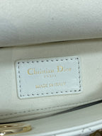 White handbag leather tag reading "Christian Dior" and "Made in Italy"