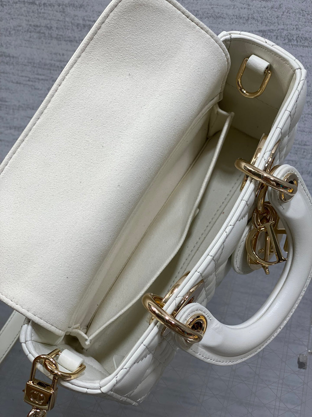 White handbag interior opening with quilted sides and gold-tone chain and clasp hardware