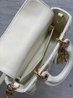 White handbag interior opening with quilted sides and gold-tone chain and clasp hardware